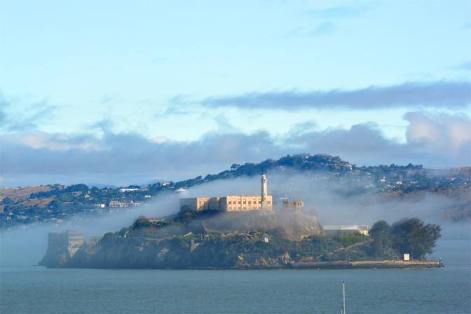 L?isola di Alcatraz, velata dalla nebbia, dista appena un miglio e mezzo dalla costa cittadina. Sono 2,4 chilometri solamente